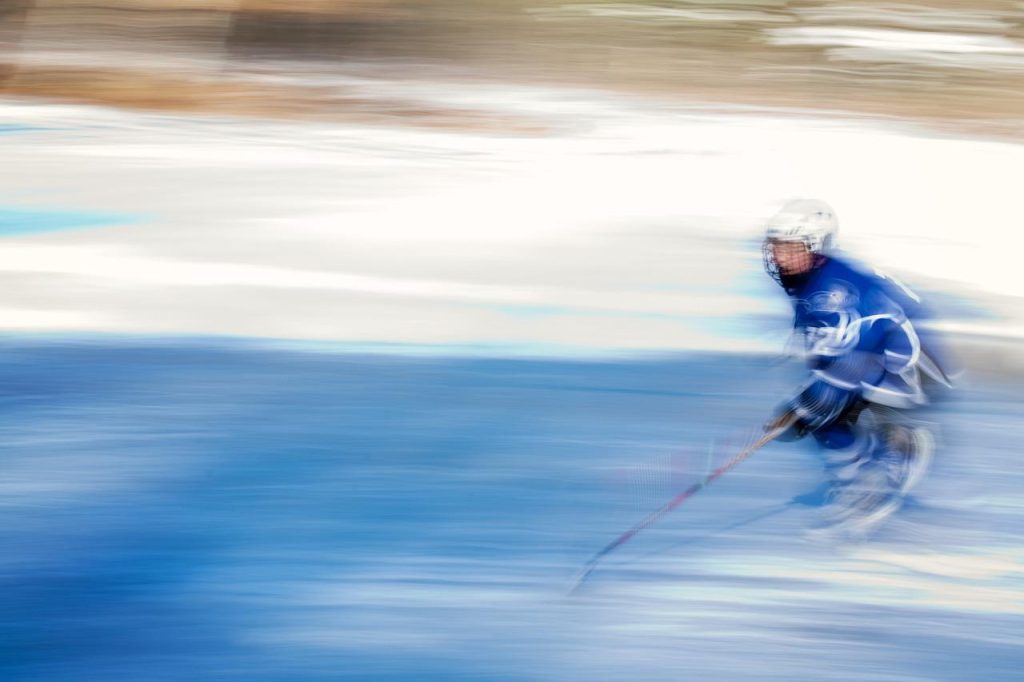 Bezoekers schaatsen op de ijsbaan in Oosterhout tijdens winterseizoen met modern complex op achtergrond
